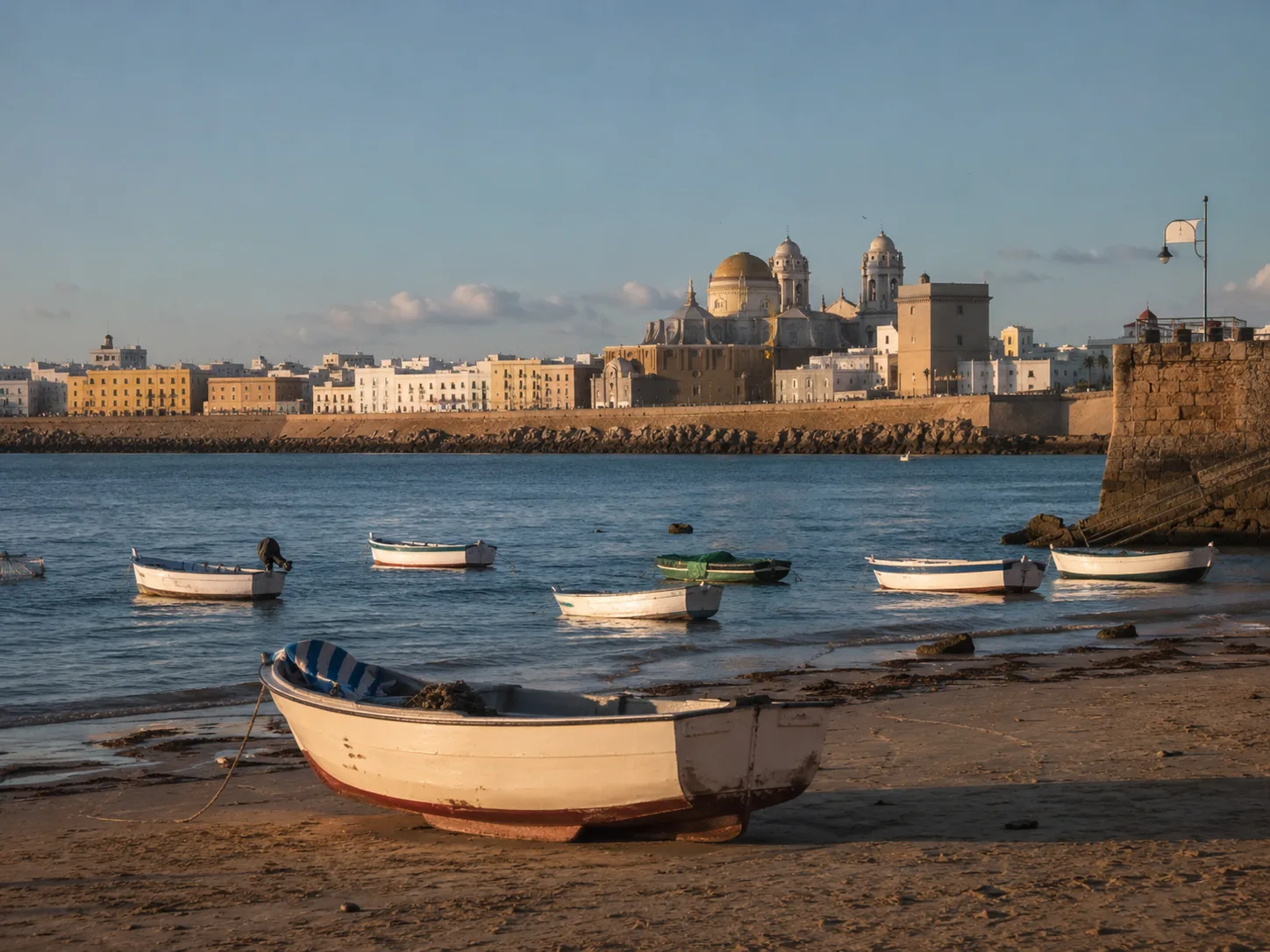 Barcas en La Caleta con la silueta histórica de Cádiz al fondo