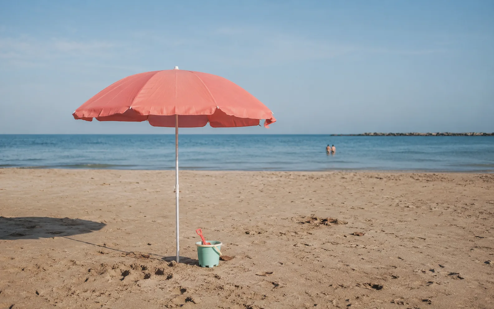 Sombrilla y juegos sobre la arena de una playa tranquila de Cádiz