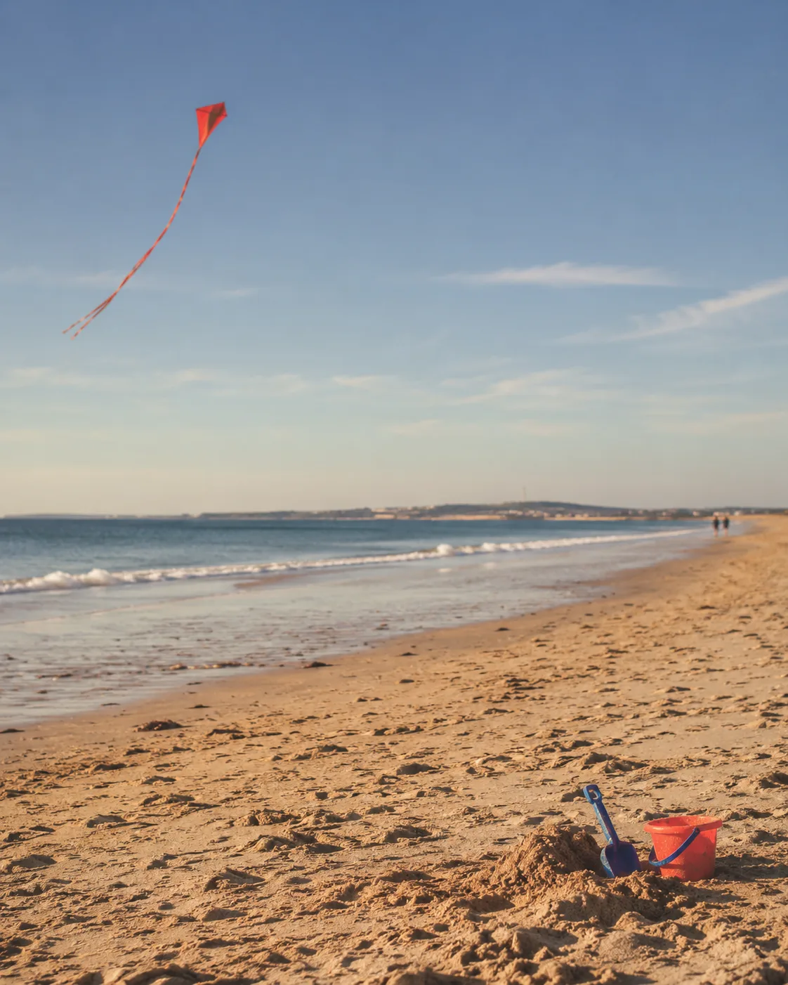 Cometa y juegos infantiles junto a la orilla de una playa de Cádiz